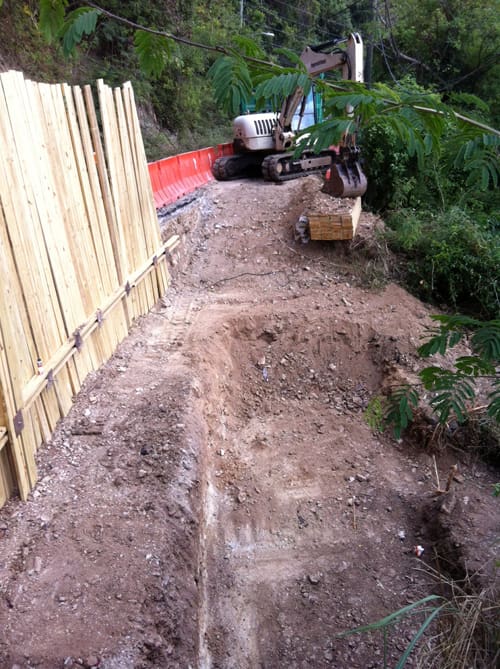 Island Roads finally got down to solid ground in the project to rebuild Centerline Road. A temporary board wall has been put in place to stablize the only passable lane while the roadbed is rebuilt.