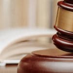 Wooden,Gavel,Resting,On,Its,End,On,A,Wooden,Table