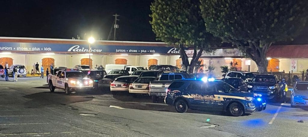 Police officers and personnel from the Medical Examiner’s Office at Vitraco Mall, where two males were shot and killed.