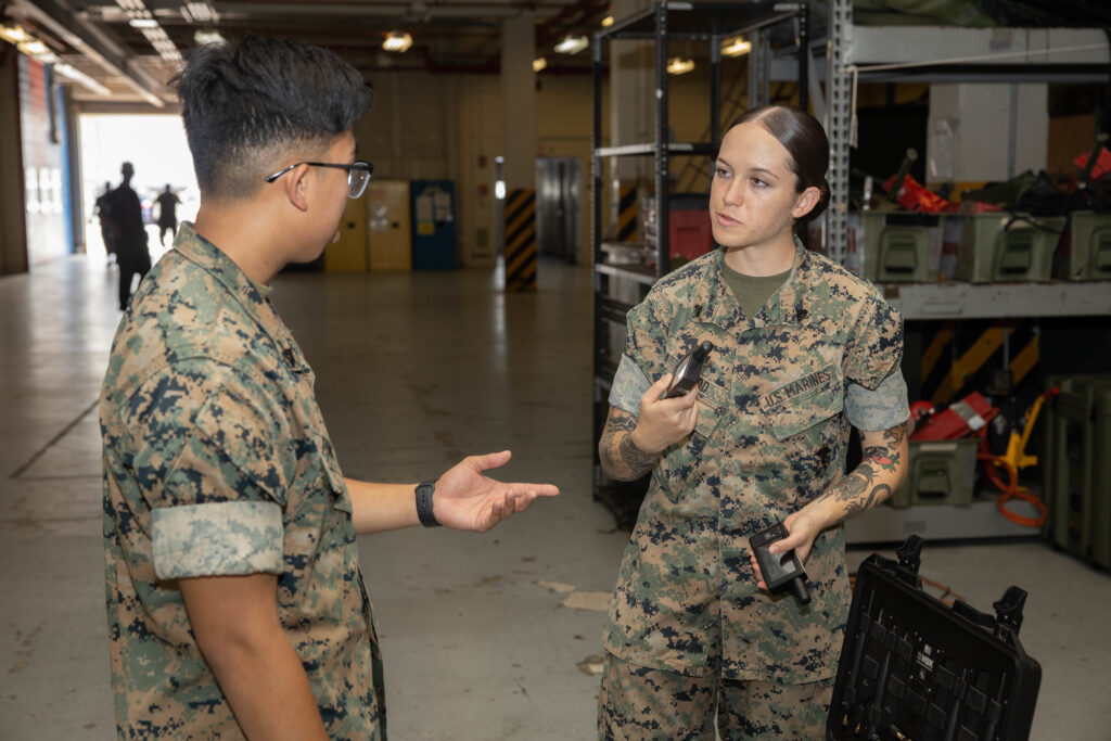U.S. Marine Corps Cpl. Esther M. Wood, right, trains Cpl. Daniel Tong, left, both data systems administrators with Communications Company, Combat logistics Regiment 37, 3rd MLG, on tactical utilization of a Mobile Broadband and Shout Nano kit on Camp Kinser, Okinawa, Japan, Aug. 12, 2022. Wood, a native of St. Croix, Virgin Islands, enlisted out of Recruiting Substation Puerto Rico in 2020. Communications Marines from across 3rd MLG conducted a Single Channel Radio Exercise to train for tactical employment of their equipment of their communications equipment (U.S. Marine Corps photo by Lance Cpl. Federico Marquez)