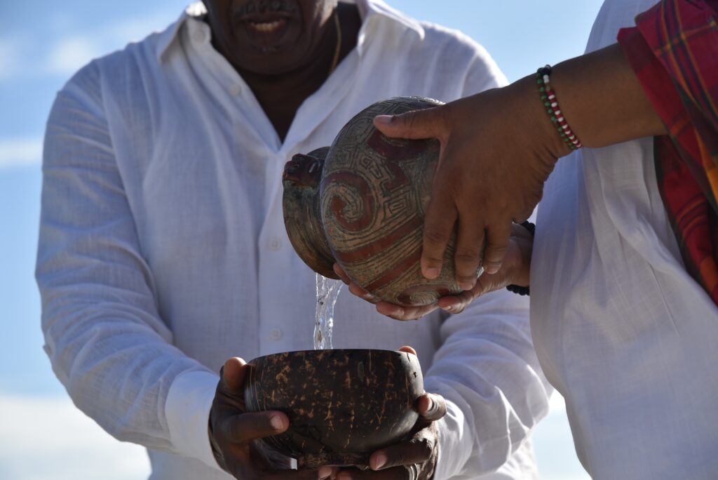 Former Sen. Myron D. Jackson and Ida “Cookie” Brown offer libations to the ancestors. (Conch Shell Media, LLC Photo)
