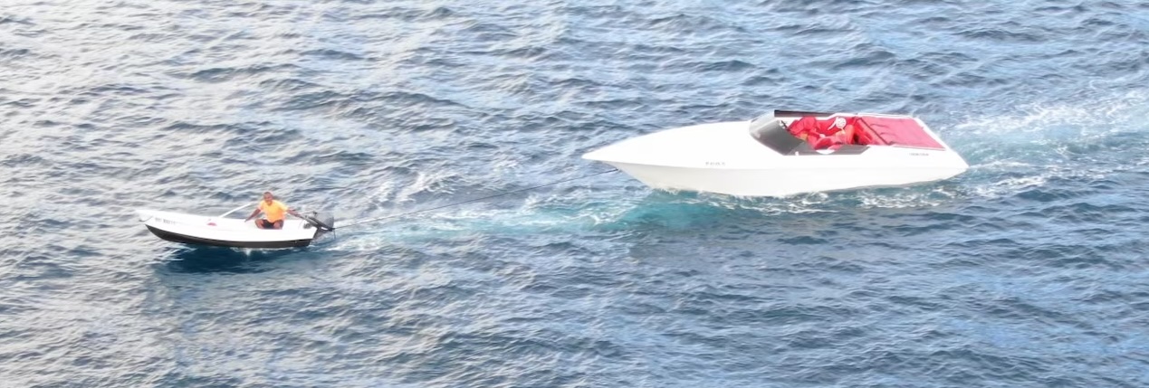 A friend of Todman Davaughn tows the motorboat he was thrown from Sunday morning back to shore. (Coast Guard photo)