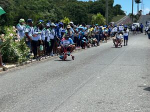 And we’re off! Agency heads come barreling down the hill for the tricycle competition. (Source photo by Nyomi Gumbs)