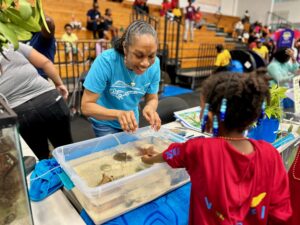 Nicole Greaux, fisheries liaison for Reef Responsible Sea Food Sustainability, introduces the petting station to young attendees. (Source photo by Nyomi Gumbs)