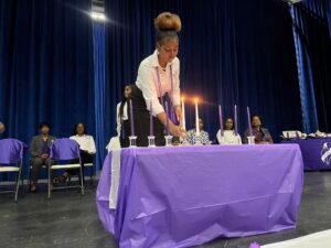 Kaylona LaRocque, NTHS secretary, lights a candle during the candlelight ceremony. (Source photo by Diana Dias)