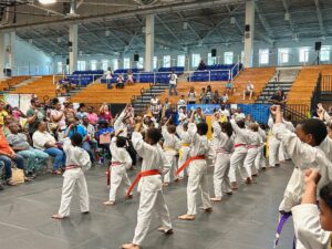 Students from Shen Dragon Karate Dojo follow instructor Celine Otto, leading them through a series of precise karate moves. (Source photo by Nyomi Gumbs)