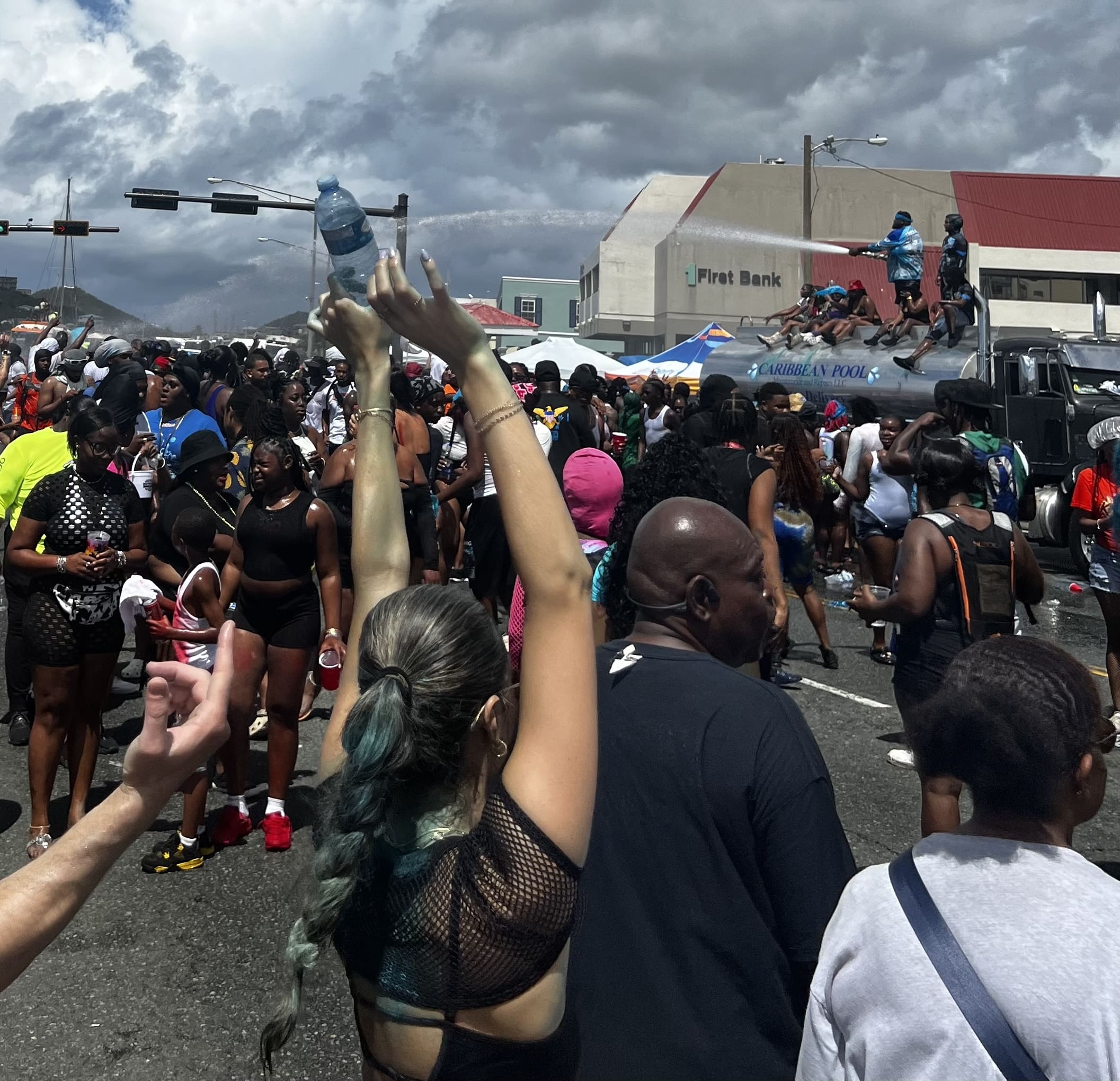 Revelers cool down under a spray of water. (Source photo by Lara Halliday)