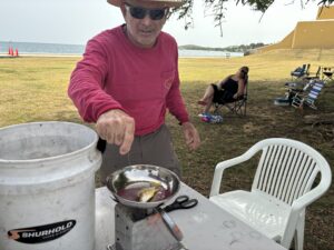 Joel Ureta, with the Golden Hook Club, cut up bait and weighed fish for the anglers. (Source photo by Susan Ellis)