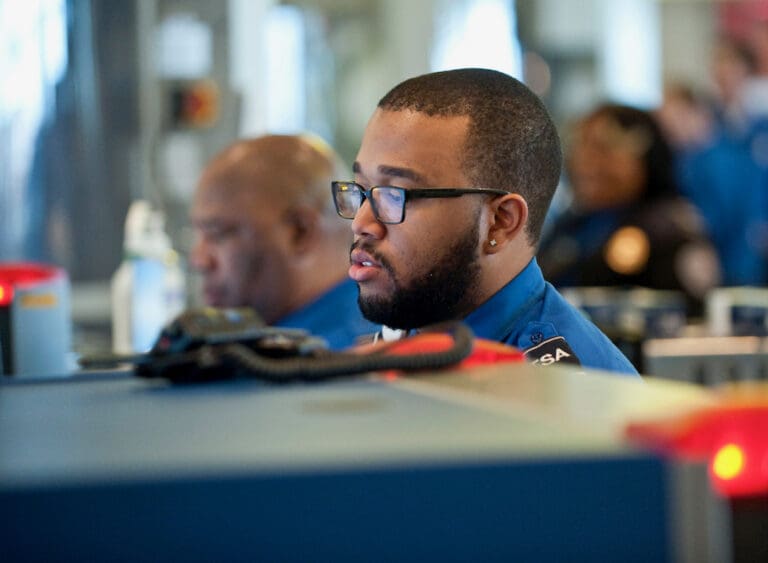A TSA agent monitors the X-ray machine in a security line. (DHS photo)