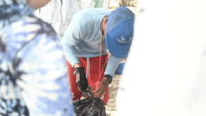 Program leader Howard Forbes Jr. weighs trash that campers picked up during beach cleanup. (Source photo by Joshua Crawford Barry)