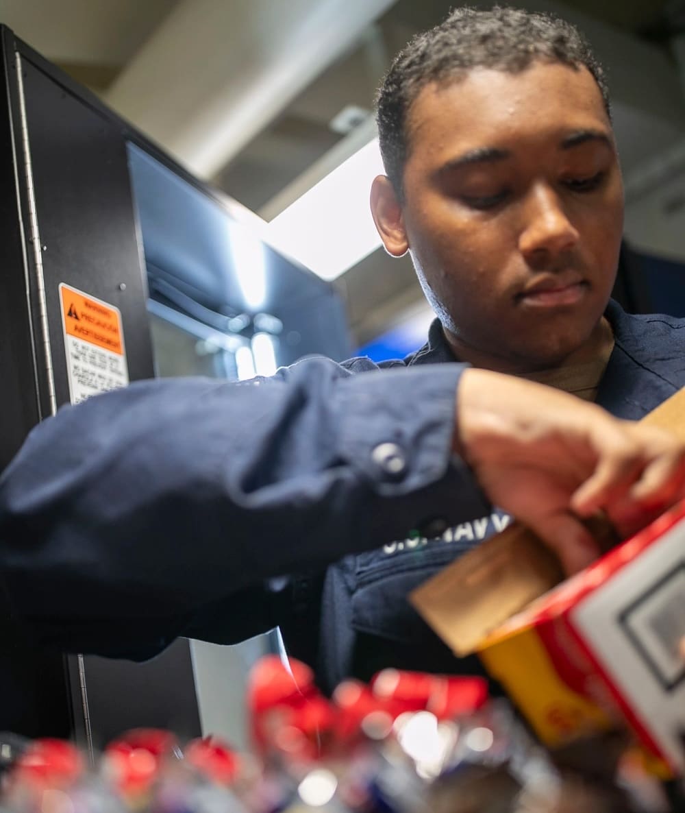 Retail Specialist Seaman Apprentice Jquel Govia of St. Thomas stocks the vending machines aboard amphibious assault carrier USS Tripoli. (U.S. Navy photo by Mass Communication Specialist Seaman Paul LeClair)