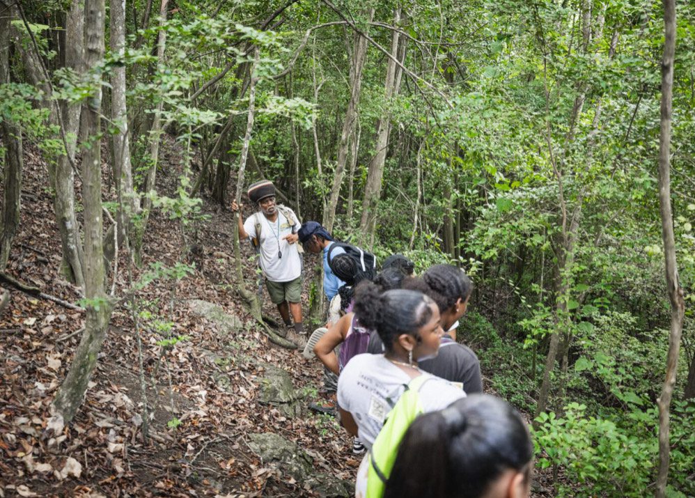 Professor Olasee Davis leads a hike through the steep terrain of the Maroon Sanctuary Territorial Park. (Photo courtesy DPNR)