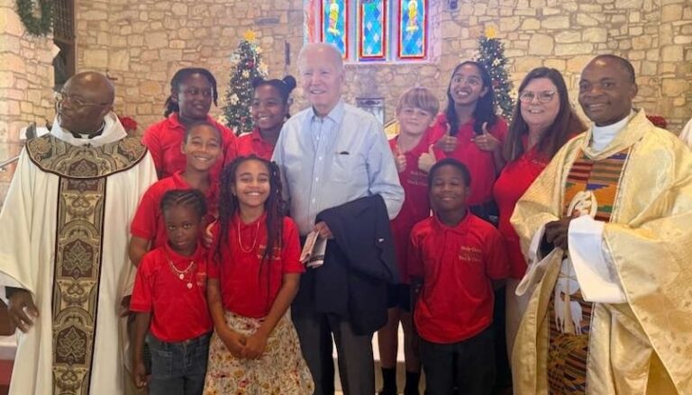 Former President Joe Biden pauses for a photo with members of the children's choir and the Rev. Louis Kemayou, left, on Sunday at Holy Cross Catholic Church on St. Croix. (Source photo by Shanell Spencer)